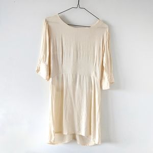 Pale peach A-line dress with back cutouts.